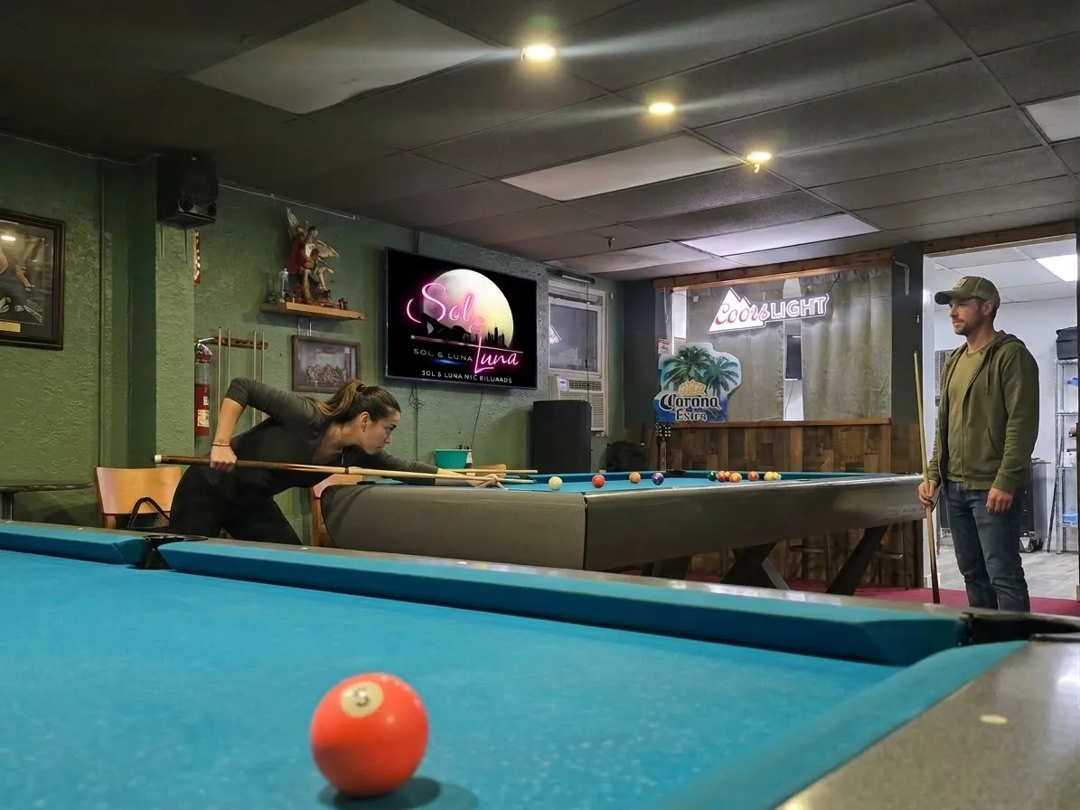 A couple playing billiards